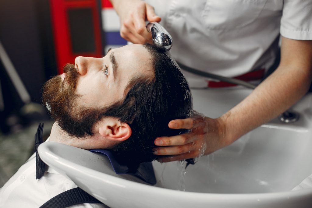 Man receiving professional hair wash at The Skin and Hair Clinic.